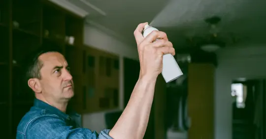 Man using mosquito spray